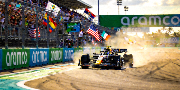 F1赛车在迈阿密赛道上飞驰，观众在看台上欢呼